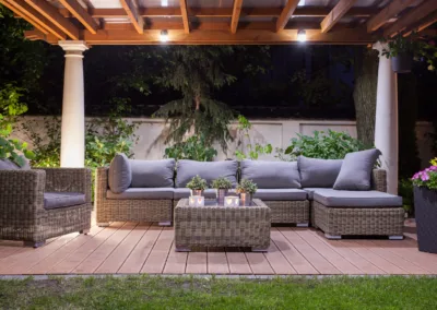 Residential backyard with outdoor furniture and canopy with lights.